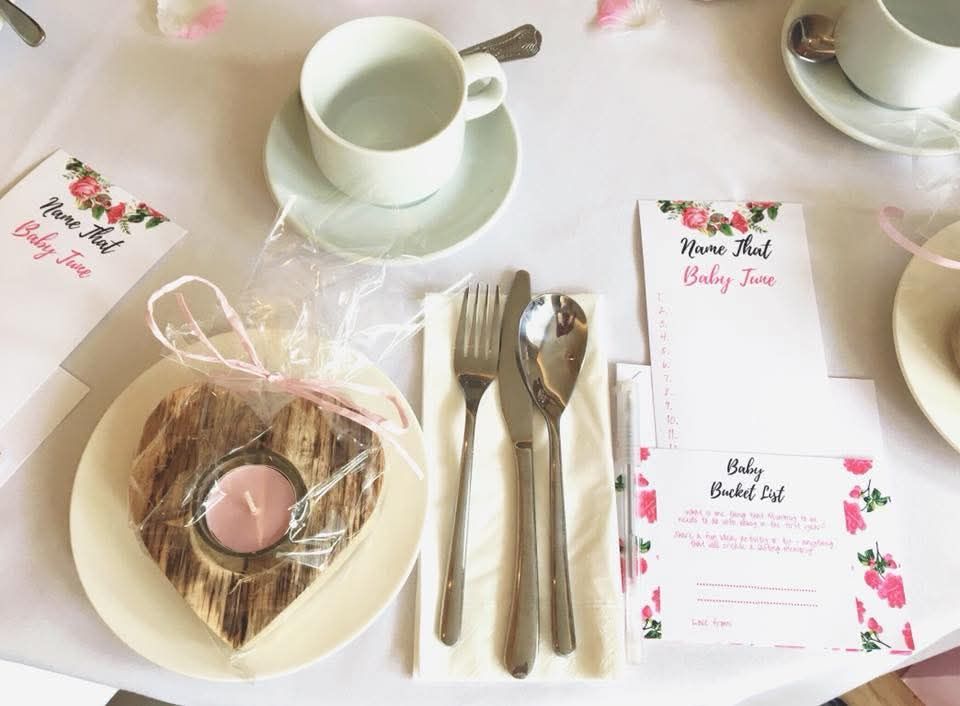 Driftwood tealight favour on side plate with cutlery, teacup, and petals.