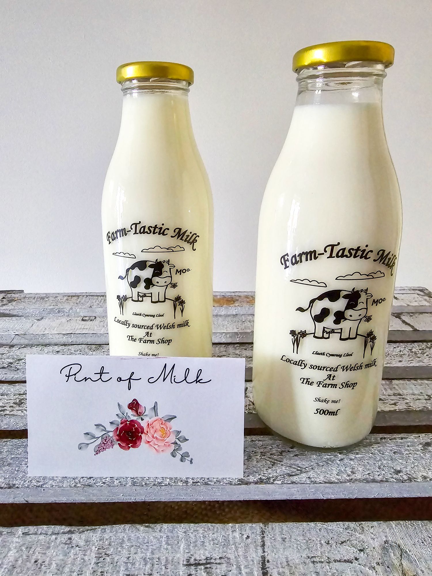 Two milk bottles with floral “milk” label on display