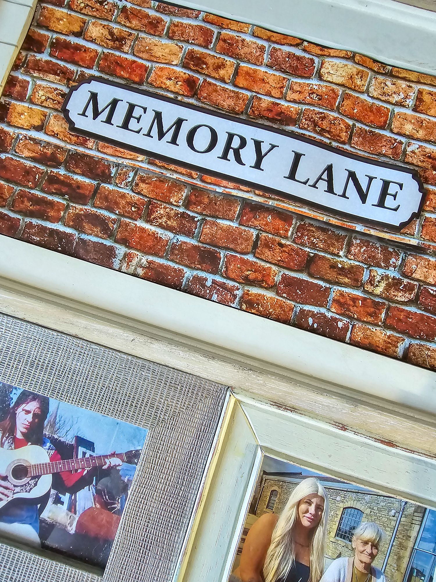 Close-up of Memory Lane poster with framed family photos nearby