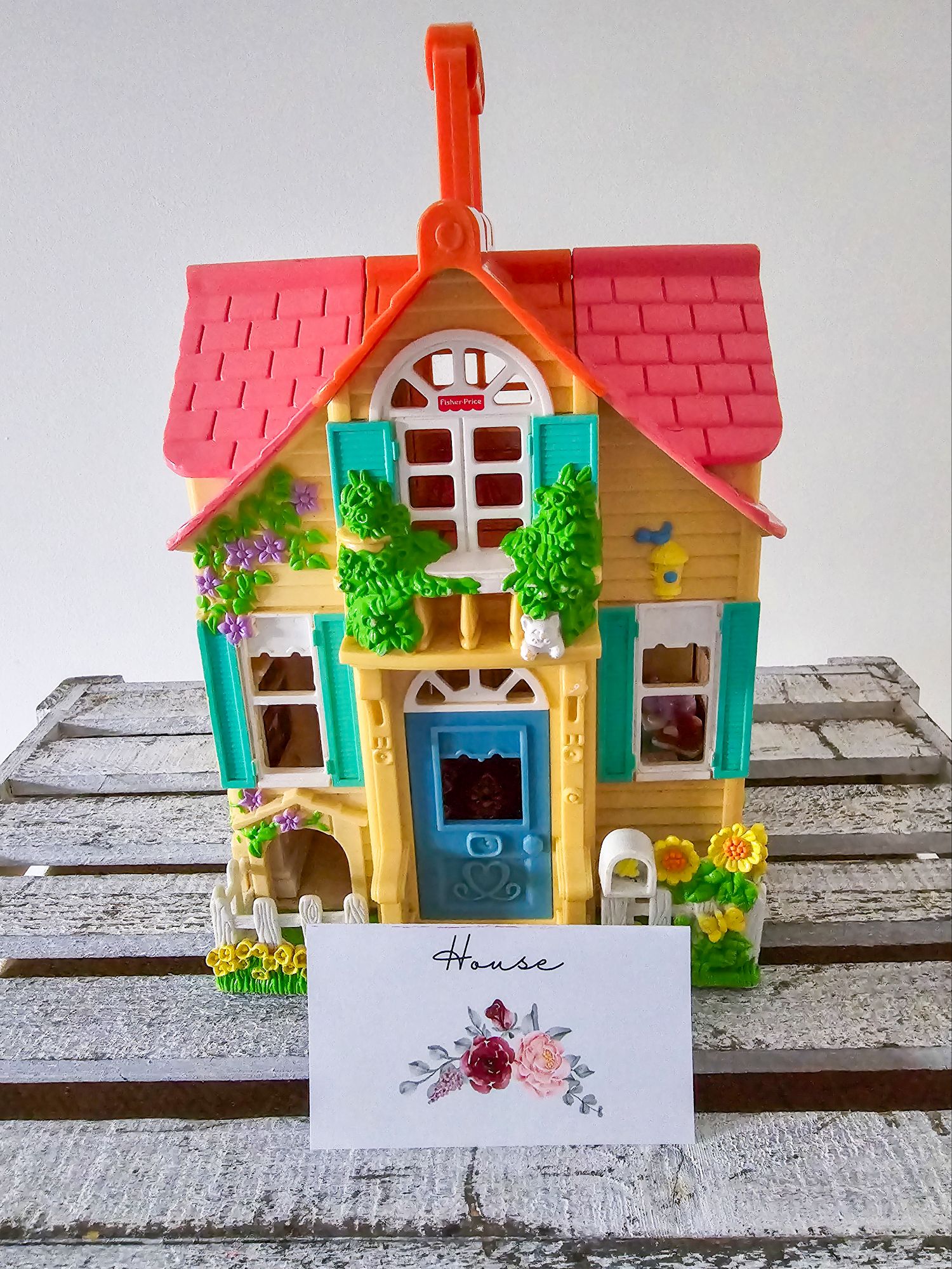 Yellow toy house with floral “house” label for Price is Right game